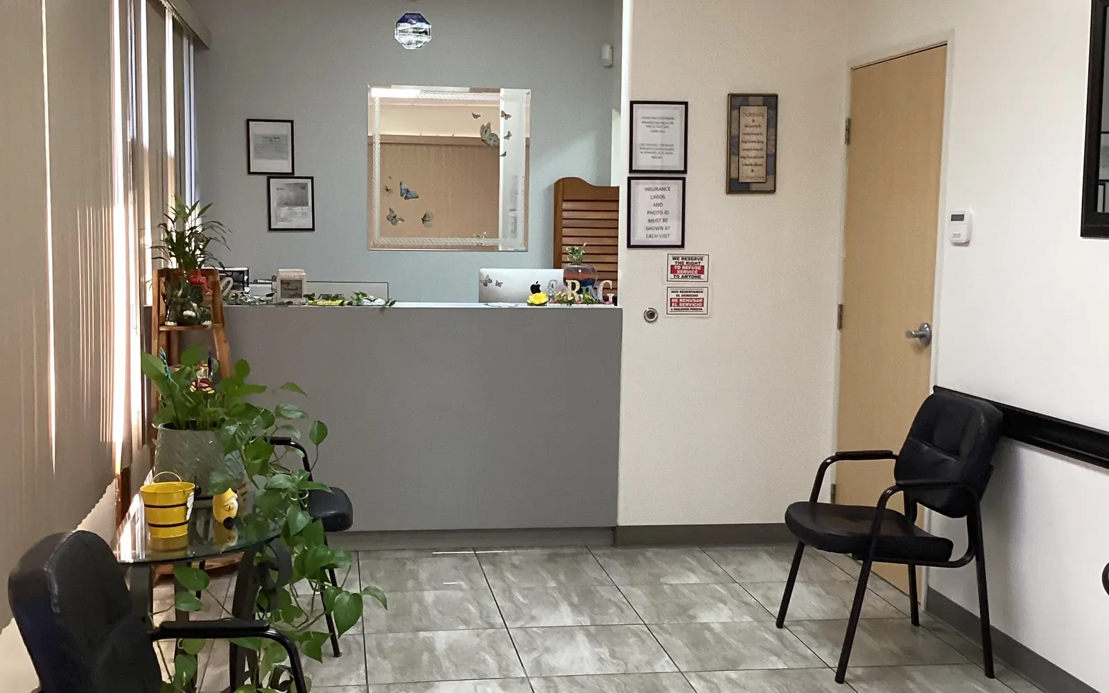 The waiting room at Diamond's Dental Inc., with natural light through window blinds, plants, and black seating